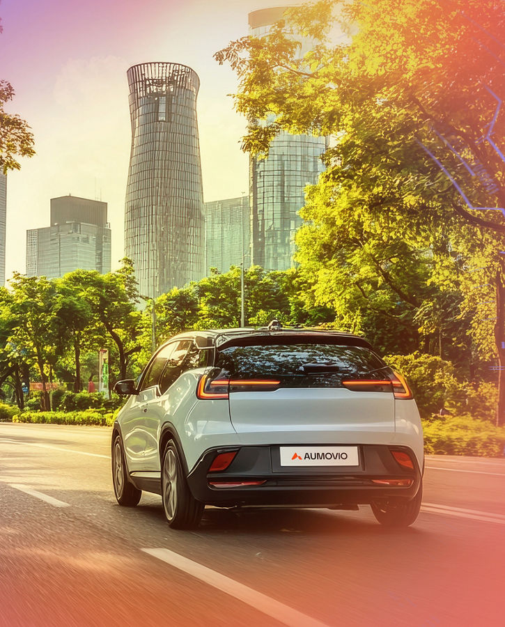 A car driving in the city with skyscrapers and trees along the street. 