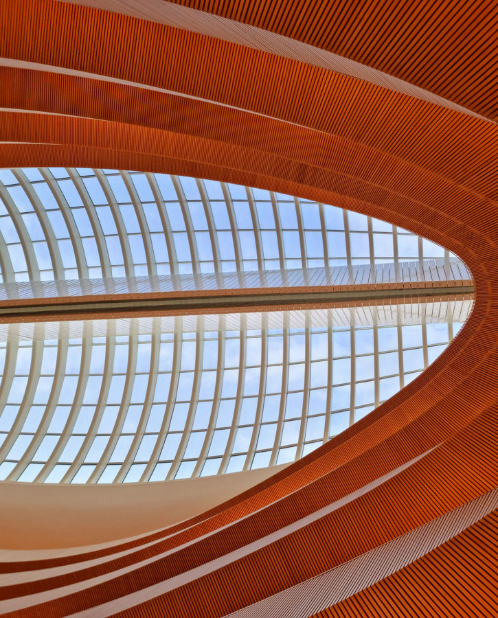 Large covered hall with wood covered floors. The image shows an architectural feature with windows inside the ceiling.