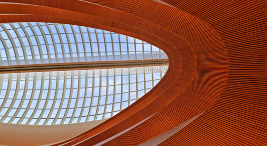 Large covered hall with wood covered floors. The image shows an architectural feature with windows inside the ceiling.