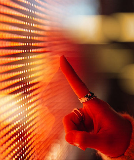 Female hand touching illuminated orange digital screen. Technology and innovation. Connecting to the future.