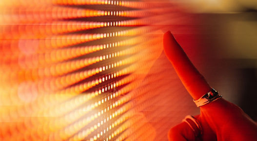 Female hand touching illuminated orange digital screen. Technology and innovation. Connecting to the future.