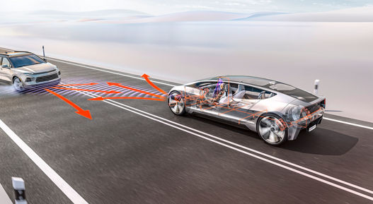 Image of AUMOVIO's semi-transparent concept vehicle on a road. A vehicle travelling in the opposite lane skids towards the concept vehicle with smoking tyres. Before the collision occurs, AUMOVIO's integrated safety systems use orange arrows to indicate a change of direction in front of the vehicle in order to avoid the collision.