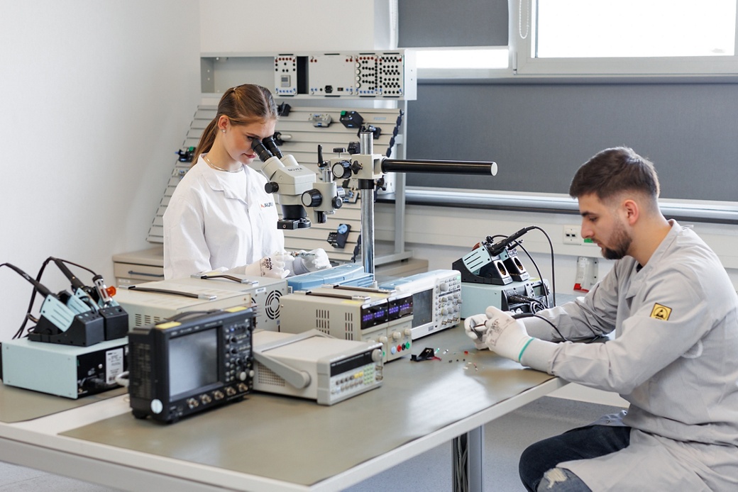 Two students working in the AUMOVIO Sibiu technical training center