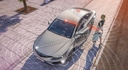 Image of an access situation in front of a vehicle, taken from above. The vehicle recognizes the car key in the woman's handbag and performs various personalized functions. The so-called PASE system enables keyless access to the vehicle and starts the engine without you having to hold the key in your hand. The vehicle system automatically recognizes the correct key when you approach and unlocks the vehicle. 