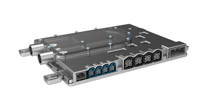Close-up view of an automotive high-performance computer (HPC) unit in a metallic housing. The component features multiple connectors on one side, including blue and black multi-pin sockets, and two cylindrical ports for high-speed data or power connections. The top surface has a patterned area with several screws securing the cover.