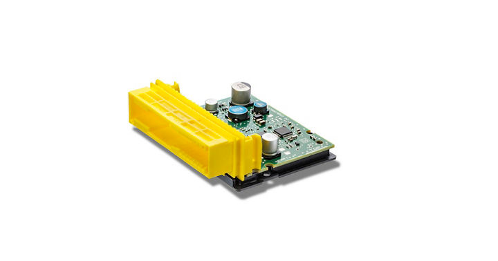 Compact airbag control unit featuring a green printed circuit board with essential electronic components such as capacitors and ICs. A bright yellow connector housing is attached for electrical connection. The design emphasizes a smaller footprint for space-constrained automotive applications.