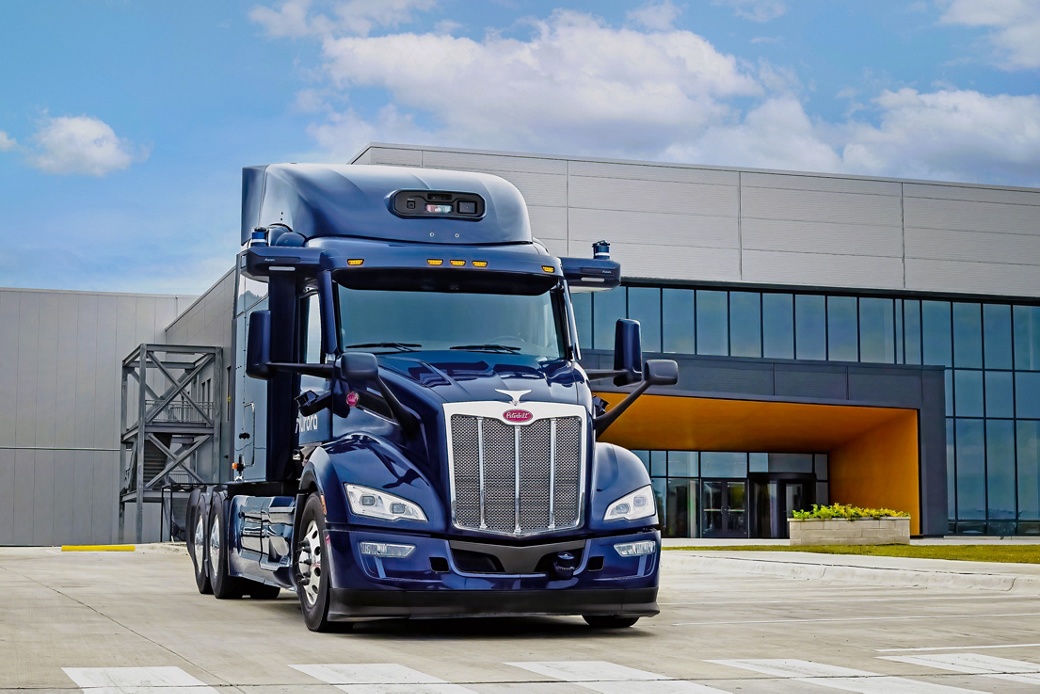 Bild eines Konzept-Lkw von AUMOVIO in Zusammenarbeit mit Aurora vor dem Gebäude der Anlage zur Realisierung kommerziell skalierbarer autonomer Lkw-Systeme. AUMOVIO und Aurora Innovation, Inc. sind eine exklusive Partnerschaft eingegangen, um die erste kommerziell skalierbare Generation von Auroras integriertem Hardware- und Softwaresystem Aurora Driver auf den Markt zu bringen.