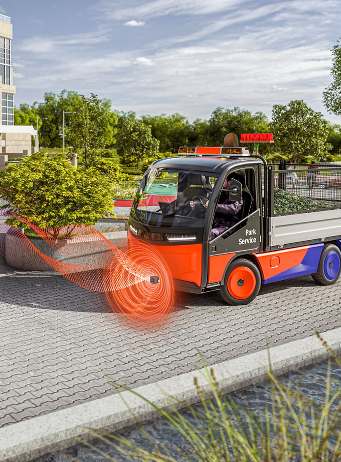A quiet electric service vehicle in a public park uses the AVAS acoustic warning system to alert a jogger who cannot see the vehicle. 