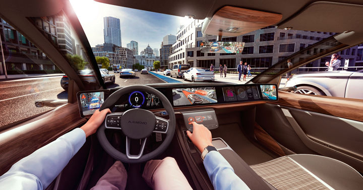 View through the windshield from inside the vehicle, from the driver's perspective over the dashboard to a traffic situation outside the vehicle. The external environment is displayed on several screens in the vehicle, including messages and warnings. AUMOVIO's state-of-the-art expertise in visualizing the vehicle and its surroundings is the result of many years of experience in the field of human vision.  Translated with DeepL.com (free version)