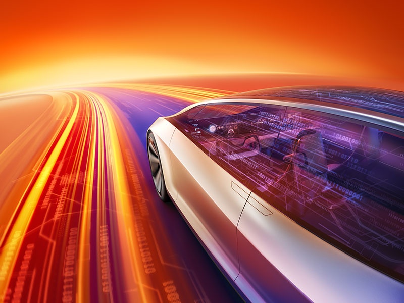 A futuristic concept car speeding along a glowing digital highway with vibrant orange, red, and purple light trails, showcasing advanced technology and innovation in mobility.