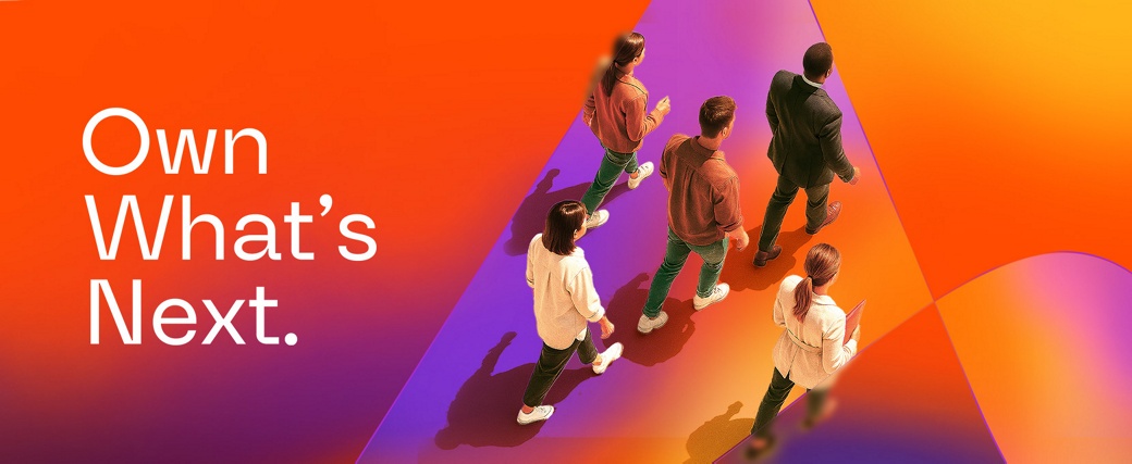 5 people walking across the AUMOVIO logo shown on the ground, from a bird's eye view