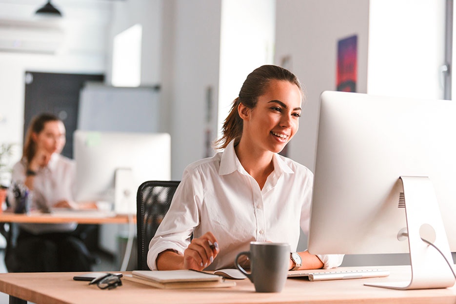 The image career opportunities shows a woman working in front of a computer monitor in an office or training room and represents your career prospects at AUMOVIO. Your future is also our future. Whether it's working abroad, further training, or studying—we offer you a wide range of career opportunities and support you on your personal path, even beyond your training.