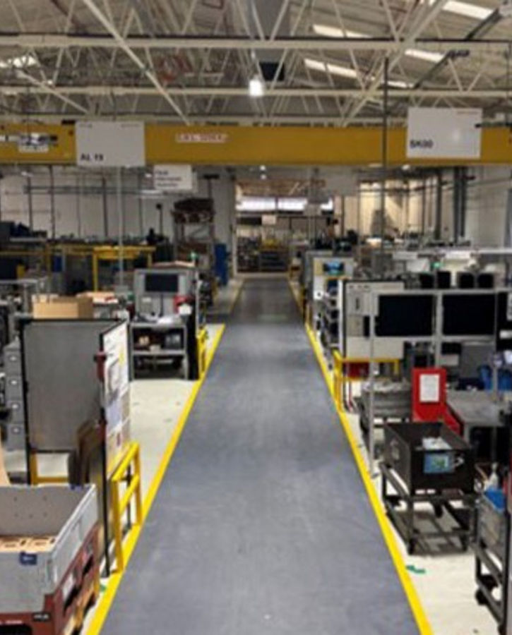 The image shows a production line for contract manufacturing. For over 50 years, AUMOVIO UK has been serving a diverse customer base, ranging from automotive OEMs across Europe to local UK manufacturers, with both small-scale and high-volume production capabilities, and a capacity to manufacture over 12 million parts per year.