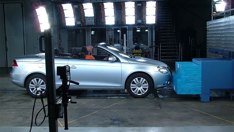 Bild einer Crashtest-Anlage mit Fahrzeug, Aufprallelement, Beleuchtung und Kamera im Vordergrund. Eine Crashtest-Anlage ermöglicht eine umfassende Bewertung der Fahrzeugsicherheit durch Frontal-, Seiten- und Heckaufpralltests sowie Überschlagtests, einschließlich natürlicher Böschungs-Szenarien. Diese kontrollierten Tests sind darauf ausgelegt, reale Unfallbedingungen nachzubilden und die Leistungsfähigkeit von Strukturkomponenten und Rückhaltesystemen zu überprüfen. Alle Verfahren entsprechen streng den nationalen und internationalen Normen wie FMVSS, VSTD, ECE und NCAP, um die Einhaltung der Vorschriften zu gewährleisten und ein Höchstmaß an Schutz für Insassen und Fußgänger zu bieten.