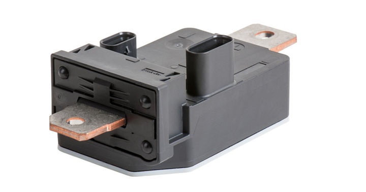 Close-up view of a current sensor module featuring a black rectangular housing with two large copper busbars extending from each side. The design includes a connector port on top for electrical interface, combining shunt and Hall effect measurement for precise current monitoring in automotive applications.