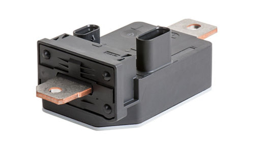 Close-up view of a current sensor module featuring a black rectangular housing with two large copper busbars extending from each side. The design includes a connector port on top for electrical interface, combining shunt and Hall effect measurement for precise current monitoring in automotive applications.