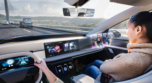 Image of a switchable partial privacy screen. The passenger enjoys digital content on a monitor in front of her without distracting the driver. Designed to minimize visual interference, Switchable Privacy Displays ensure the driver's attention remains fully on the road while co-drivers enjoy immersive entertainment.
