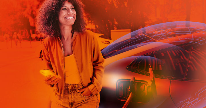 A woman is smiling as she stands next to her electric car at a charging station in a city environment. The scene captures modern transportation and eco-friendly living.