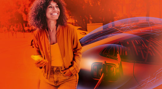 A woman is smiling as she stands next to her electric car at a charging station in a city environment. The scene captures modern transportation and eco-friendly living.