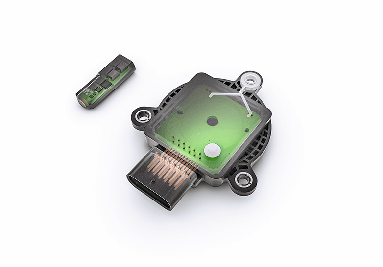 Bild, das einen Rotorpositionssensor mit abgenommener Abdeckung zeigt, wodurch die interne grüne Leiterplatte und die elektronischen Komponenten sichtbar werden. Daneben befindet sich ein separates kleines Sensormodul, das das fortschrittliche Design für die präzise Rotorpositionserkennung in elektrischen Antriebssystemen veranschaulicht.