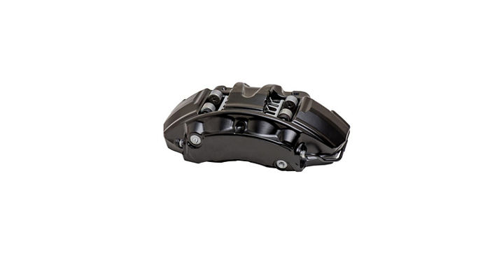 Close-up view of a fixed-type brake caliper in black finish. The component features a robust metallic body with multiple pistons and mounting bolts, designed for high-performance braking systems.