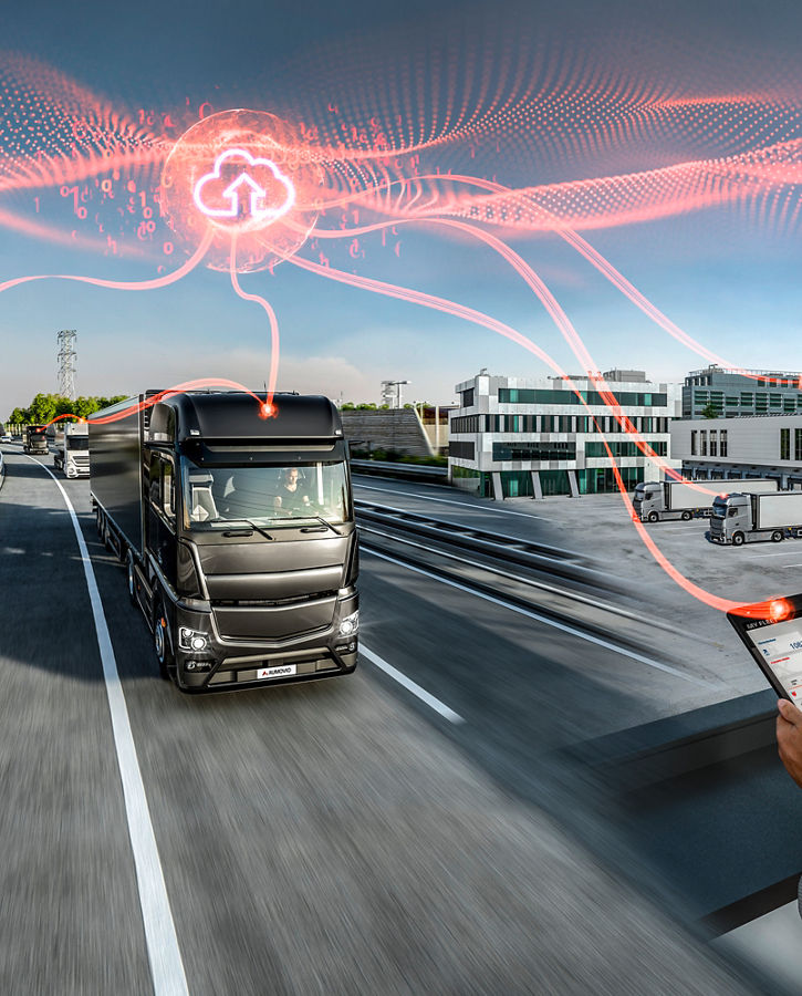 Connected fleet management concept showing heavy-duty trucks in a modern service workshop and on a highway. A person monitors vehicle data on a tablet while cloud-based connectivity is visualized with red digital lines linking trucks to a central cloud icon. The scene combines indoor maintenance and outdoor logistics under bright daylight.