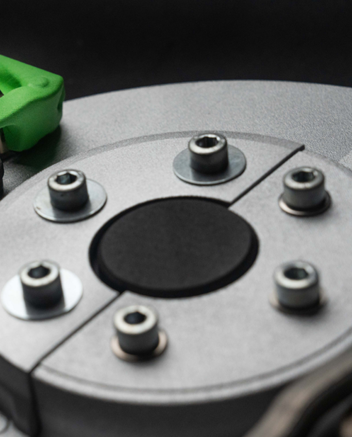 Close-up view of a high-performance car brake system featuring a metallic brake disc with multiple bolts and a bright green brake caliper.