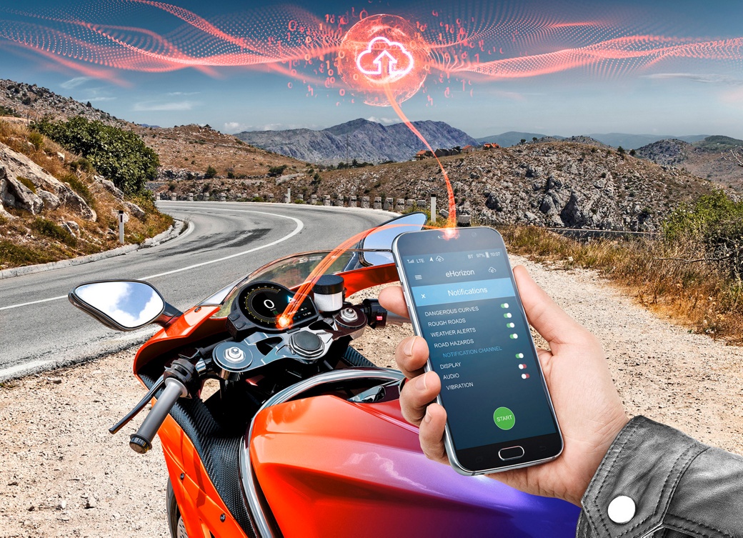 The picture shows a mobile phone in a motorcyclist's hand connecting to the cloud. The IoT gateway is the heart of connectivity, allowing your motorcycle to tap into the power of the internet.