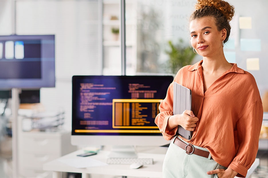 The IT & software image shows a woman in an office or training room in front of a desk with a large monitor and represents your potential areas of work at AUMOVIO. We want to give young people guidance and create opportunities for them—regardless of their gender, background, or life path. With initiatives focused on promoting STEM subjects, integration, and equal opportunities, we support talented individuals in discovering their strengths and finding their own path.
