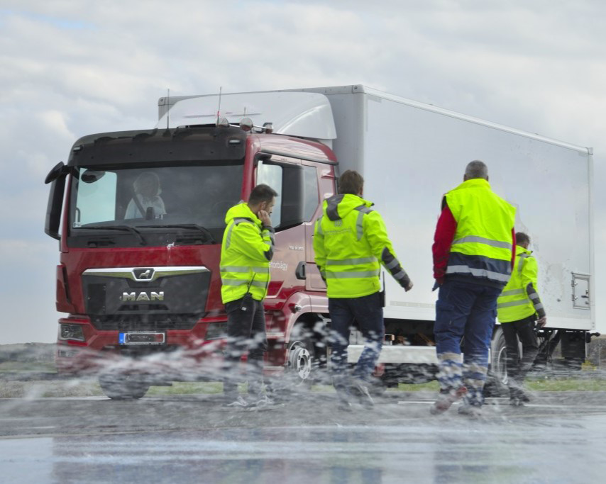 Truck in the back with aquaplaning test and four people in the front