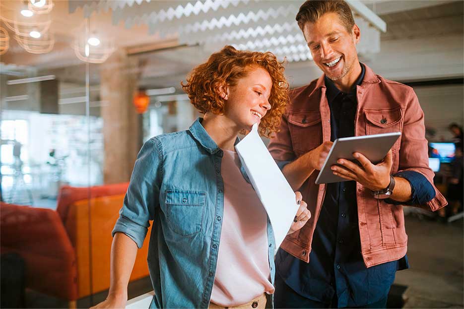 The image learning from the best, showing two students talking with documents in their hands, represents our modern training centers, where our highly qualified trainers are available to assist you around the clock. Comprehensive onboarding, direct contact persons, and intensive exam preparation are all part of your training at AUMOVIO.