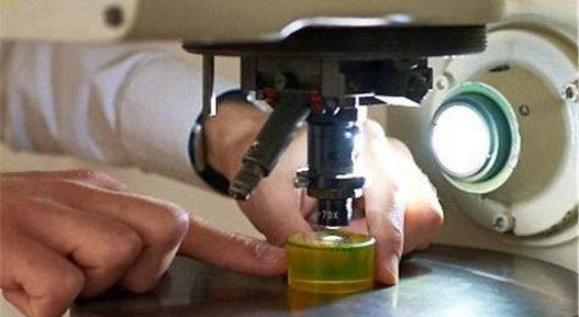 Image of a person performing a material analysis using a microscope