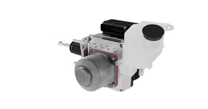 Close-up view of the MK C2 brake system module. The unit includes a metallic cylindrical actuator, a black electronic connector block, and a translucent white brake fluid reservoir with a black cap. The design highlights the integration of hydraulic and electronic components for advanced braking systems.