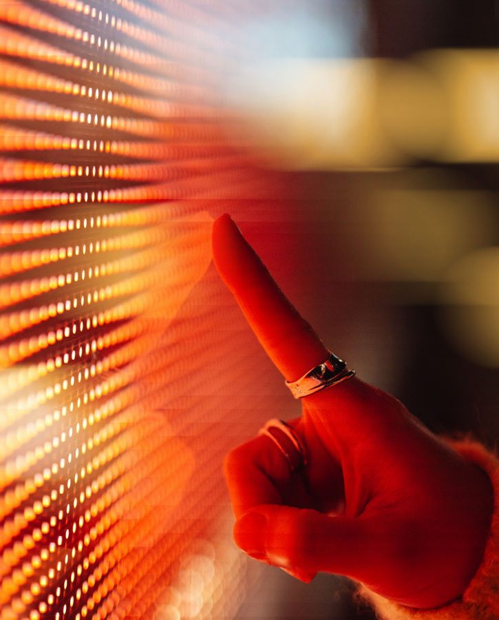 Female hand touching illuminated orange digital screen. Technology and innovation. Connecting to the future.
