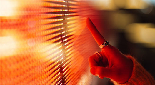 Female hand touching illuminated orange digital screen. Technology and innovation. Connecting to the future.