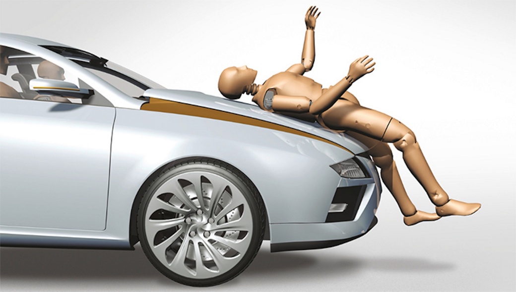 Image of a crash test dummy lying on a hood. A pedestrian protection dummy is used for component testing to ensure both occupant and pedestrian safety under various impact conditions. Out-of-Position (OOP) scenarios, airbag deployment trials, and ejection mitigation strategies are evaluated to verify system reliability. Additionally, tensile tests, structural assessments, and bumper pendulum tests are conducted to analyze material strength and energy absorption. These combined methods provide a comprehensive approach to validating safety systems and improving overall crash performance.