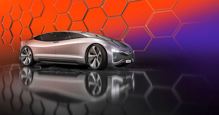 Futuristic silver concept car displayed against a vibrant orange and purple background with hexagonal patterns.