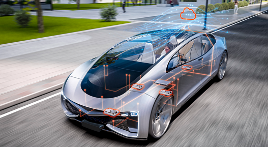 Futuristic silver car driving on an urban street with transparent overlays showing electronic architecture and server-zone connectivity. Orange circuit lines highlight key control units, while a cloud icon above the vehicle represents cloud-based data exchange and advanced software-defined vehicle technology.