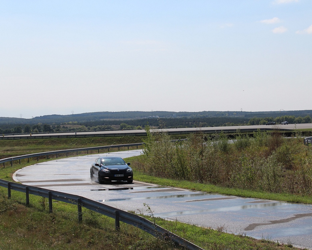 black car driving on wet test track