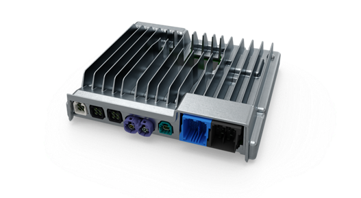 Close-up view of a smart cockpit high-performance computer (HPC) unit with a metallic housing and integrated cooling fins. The front side features multiple connectors in different colors, including black, purple, green, and blue, designed for data, power, and communication interfaces. The design emphasizes heat dissipation and robust connectivity for advanced in-vehicle systems.