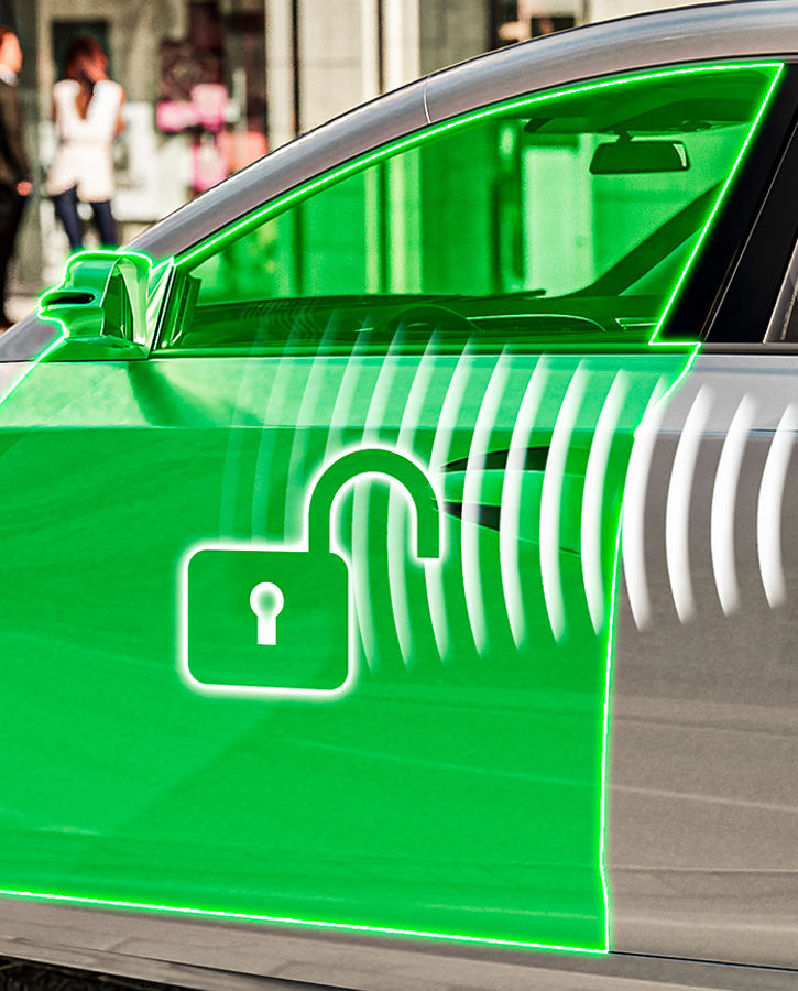 Image of a woman walking to her vehicle. The driver's door lights up green and an open lock symbol illuminates. Her smartphone, which is in her handbag, also displays the open lock symbol and is visibly connected to the door by white radar waves. AUMOVIO's combination of door-related software functions enhances intelligent control and safety for vehicle entry and exit. This seamless combination improves  convenience,  safety, and the overall  user experience.