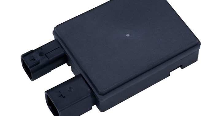 Flat rectangular radar sensor with dual connector ports for vehicle integration.