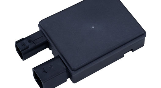 Flat rectangular radar sensor with dual connector ports for vehicle integration.
