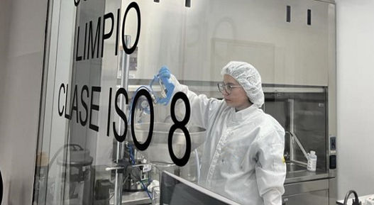 A photo of a person behind a large glass window in a laboratory. Technical cleanliness is a specialized methodology used to assess and control particulate contamination in components and systems, particularly in industries where even microscopic debris can compromise performance, reliability, or safety.