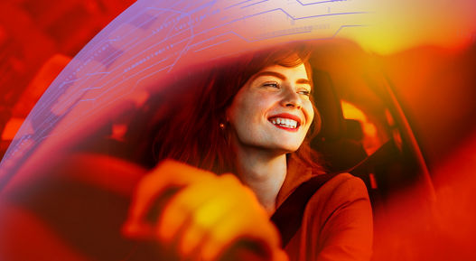 Beautiful young woman driving her new car at sunset. Woman in car. Close up portrait of pleasant looking female with glad positive expression, woman in casual wear driving a car