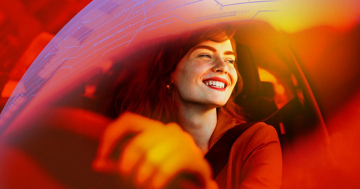 Beautiful young woman driving her new car at sunset. Woman in car. Close up portrait of pleasant looking female with glad positive expression, woman in casual wear driving a car