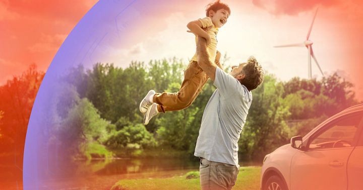 A person lifts a child joyfully in a scenic outdoor setting with lush greenery, a wind turbine in the background, and a car parked nearby, symbolizing family moments and sustainable living.