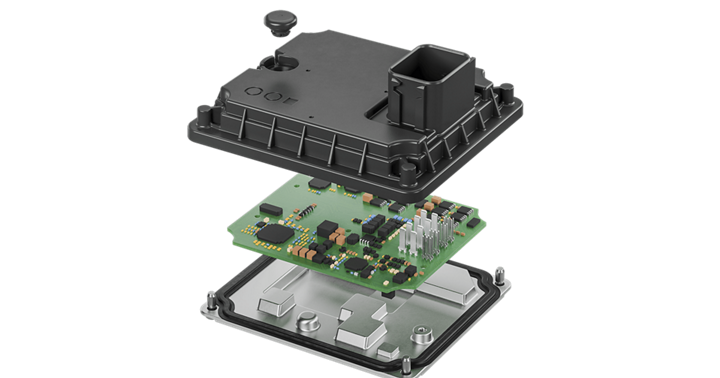 View of an automotive twin motor control unit showing three layers: black top housing with connector, green circuit board with electronic components, and silver bottom casing. Represents advanced power electronics and motor control technology for electric vehicles.