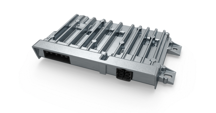 Close-up view of a vehicle control high-performance computer (HPC) unit with a robust metallic housing and integrated cooling fins. The design includes multiple mounting points and two connector ports on the front side for power and data interfaces. The structure emphasizes durability and heat dissipation for advanced automotive control systems.