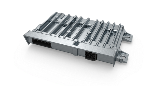 Close-up view of a vehicle control high-performance computer (HPC) unit with a robust metallic housing and integrated cooling fins. The design includes multiple mounting points and two connector ports on the front side for power and data interfaces. The structure emphasizes durability and heat dissipation for advanced automotive control systems.